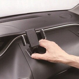 車内のダッシュボードに、耐熱性のあるスコッチ® 超強力両面テープ（車内用）を使って、スマートフォンホルダーをしっかり取り付ける。